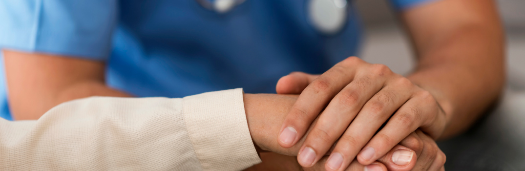 A HCP holding a hand.