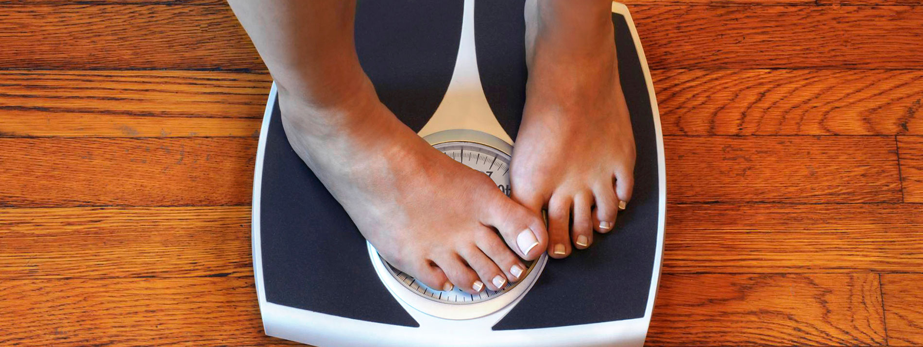 The feet of a woman standing on a weight.