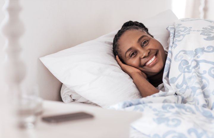 Woman lying in a bed and smiling